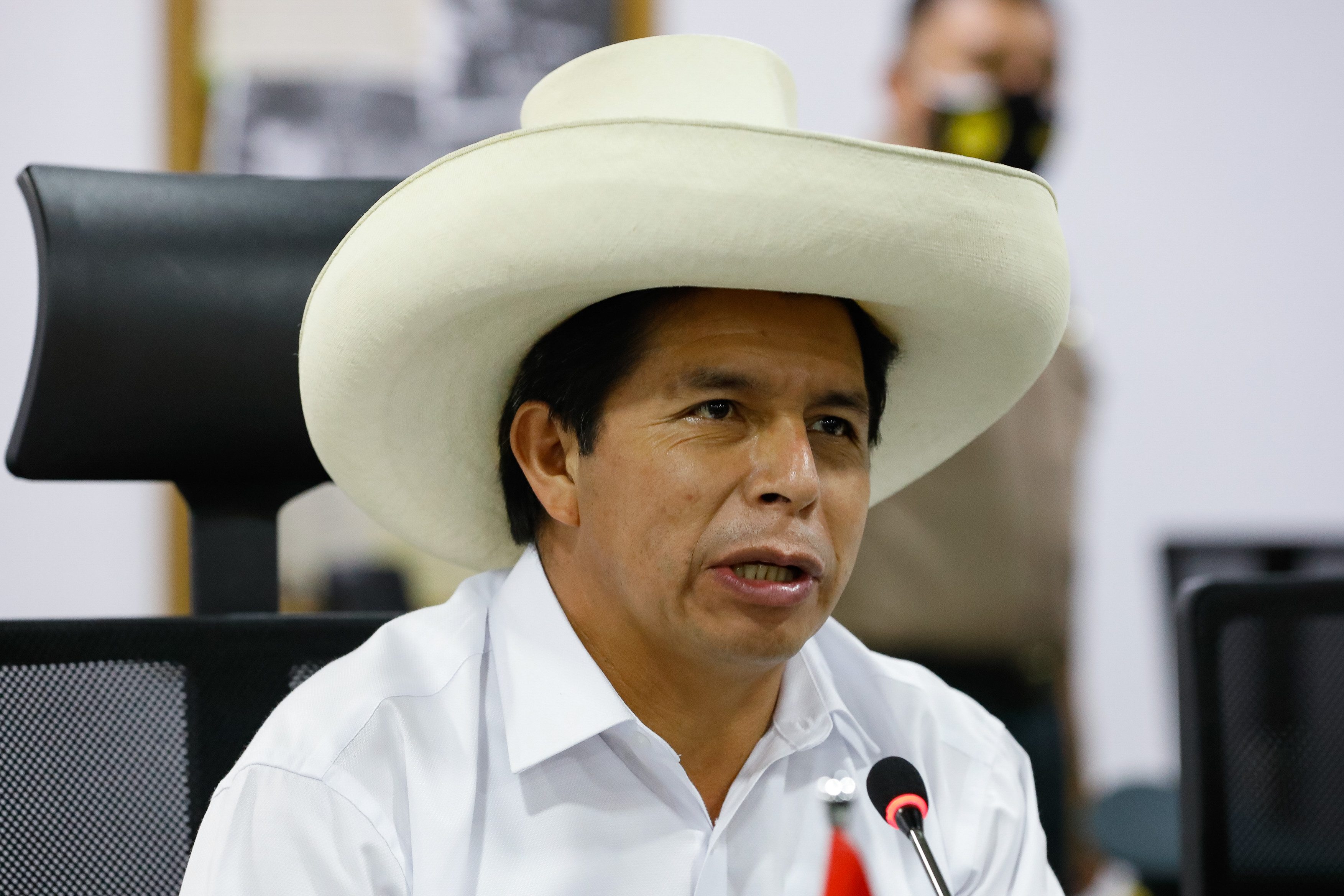 Pedro Castillo, con sombrero blanco, habla ante un micrófono